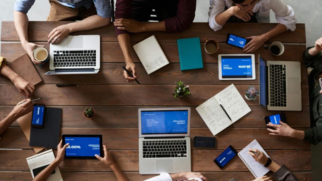 Birds eye view of group round table with their laptops 16 x9.