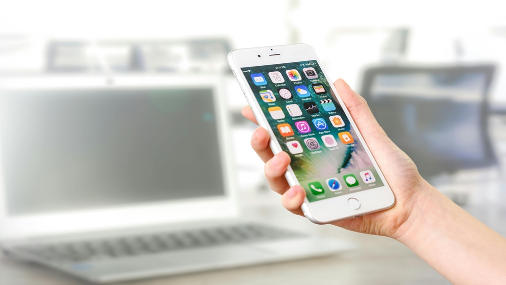 A hand holding a smartphone in their hand.